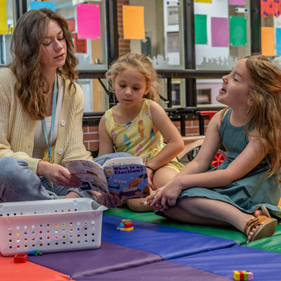 Teacher reading to two preschool children
